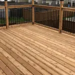 a wooden deck with railing built by stittsville deck builder overlooking a row of suburban townhouses.