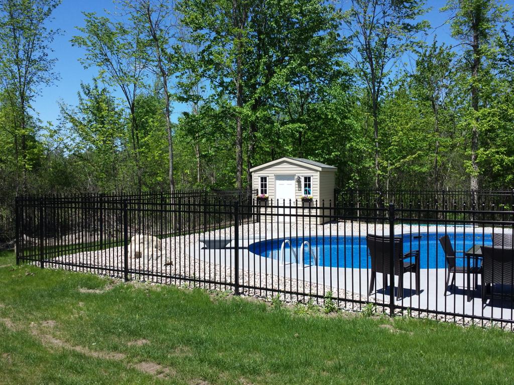 A backyard with a pool and fences.