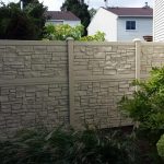 A simtek fence, offering numerous benefits, divides residential properties with a well-maintained garden in the foreground.
