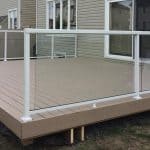 A wooden deck featuring a glass railing, constructed by deck builders in Ottawa.