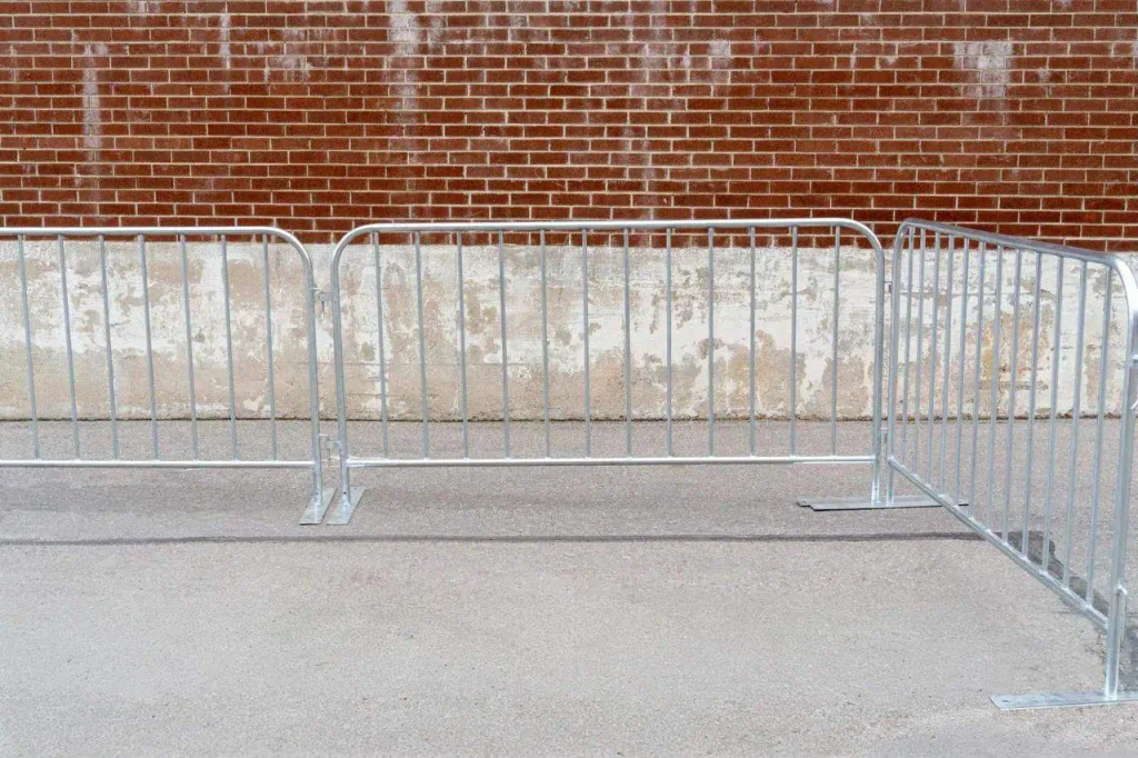 silver metal barricades stand on the interlock paving in front of a brick wall with weathered paint, capturing a quintessential ottawa scene, temporary construction fencing ottawa